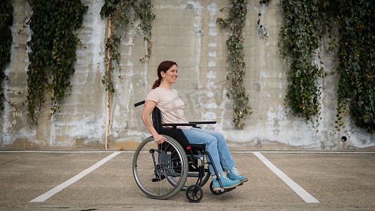 女人坐在停车场的轮椅上。