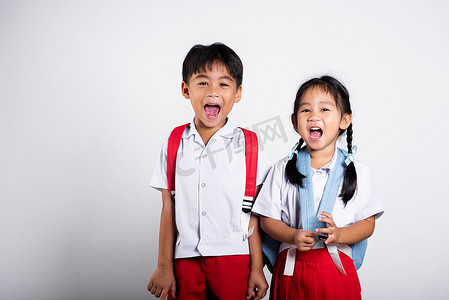 裤子裙子摄影照片_两个亚洲学生孩子女孩男孩学童兄弟姐妹微笑快乐穿着学生泰国制服红色裤子裙子