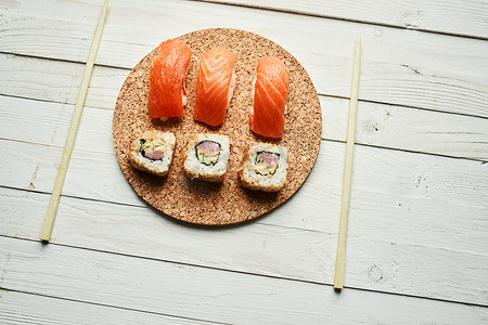 日本料理水彩摄影照片_寿司卷日本料理顶视图亚洲木桌