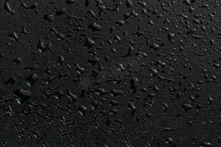 黑色平橡胶表面宏观背景上的水滴