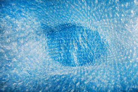 碎屏摄影照片_全屏蓝色背景上一袋包装气泡膜的内部空间