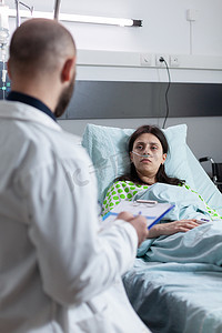鼻插管患者在私人病房接受氧气，看着医生提出治疗方案