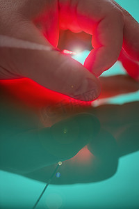 探头末端的亮光源通过左手大指和食指之间的激光进行治疗