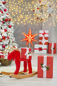 圣诞节礼物棒摄影照片_圣诞工作室装饰很棒的主意，主要是白色和红色的新年树，上面有雪，在令人惊叹的 LED 灯烘烤和巨大的纸星下有大量的礼物。