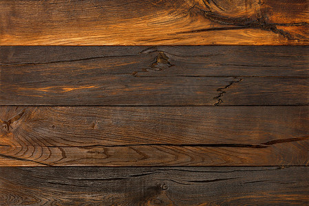 木材质地摄影照片_深色旧木材的背景和质地，有裂缝和结。