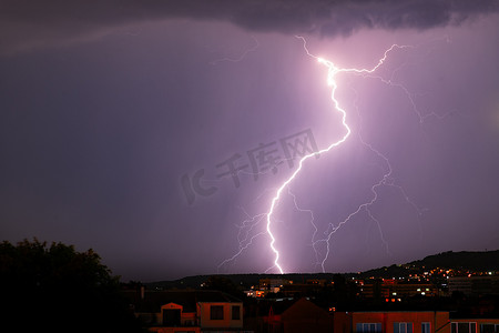 蓝色闪电摄影照片_城市上空令人兴奋的强大闪电、拉链和雷雨
