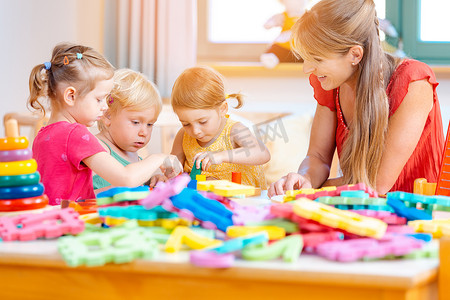 幼儿园招生蓝色摄影照片_一群孩子和老师在幼儿园玩耍