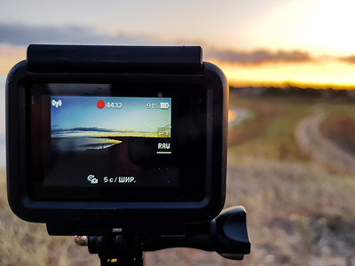 初秋，在河口附近的草地上拍摄日落延时的运动相机。