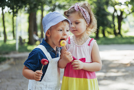 上品气度摄影照片_快乐的孩子们在棍子上品尝糖果