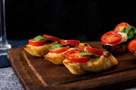 典型的意大利意式烤面包片或西班牙塔帕纸，配樱桃番茄、罗勒和费城型可涂抹奶酪。