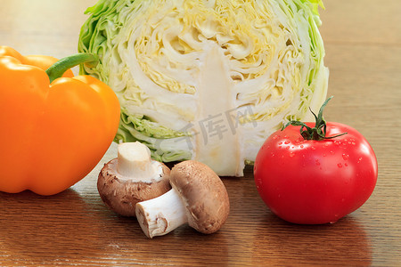 胡椒摄影照片_新鲜的圆白菜、蘑菇、胡椒和蕃茄在桌上