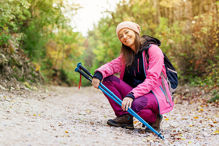 徒步旅行者女孩蹲在山上一条宽阔的小路上。