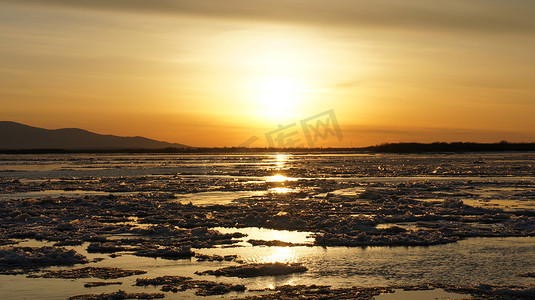 河上美丽的橙色日落，冰漂