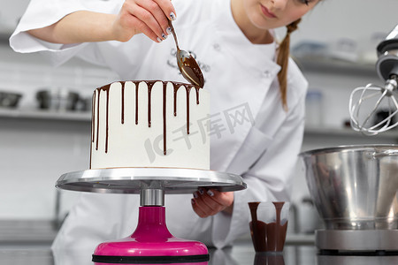 糕点师用巧克力条纹装饰蛋糕