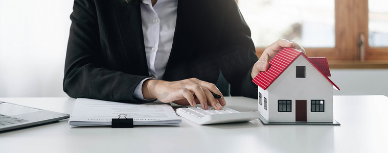女会计师或银行工作人员在办公室使用计算器来计算房屋贷款信用官僚机构。
