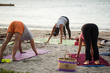 毛里求斯印度洋空荡荡的海滩上，妇女们在做瑜伽练习或支撑鸽子姿势。