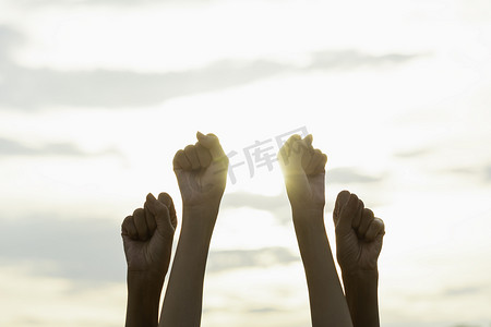 人们举起拳头的手显示出与天空 bac 强大的力量