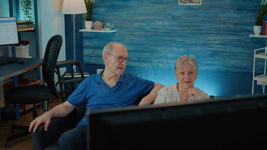 在电视上看电影的老年夫妇在客厅享受退休生活