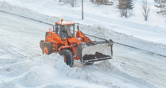 城市服务摄影照片_冬季从雪中清洁和清洁城市道路