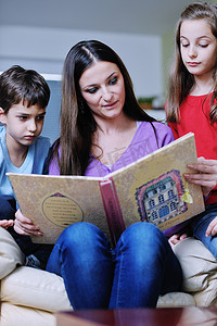 年轻的妈妈在家里和孩子们一起玩，看书