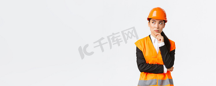身着安全帽、反光夹克、左上角、思考、寻找解决方案的周到有创意的亚洲女工程师。