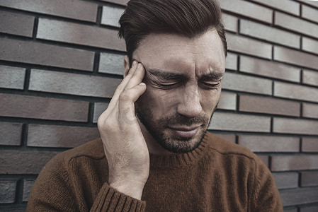 情感疯狂的男性头像大声喊叫，对某人或某事感到恼怒，表达负面情绪，孤立在砖墙背景中。