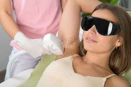 在美容诊所腋窝接受脱毛激光治疗的妇女