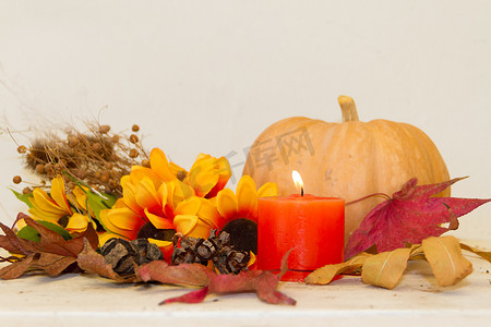 白色背景中秋收的南瓜和点燃的蜡烛