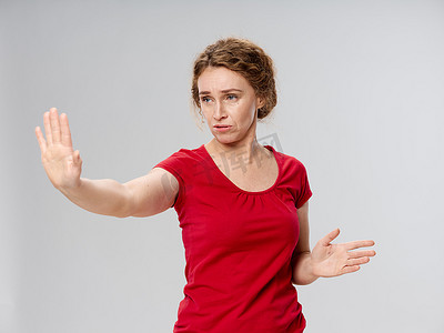 身穿红色 T 恤的老妇人在她的生活方式工作室前手牵着手