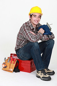 年轻工匠坐在工具箱上