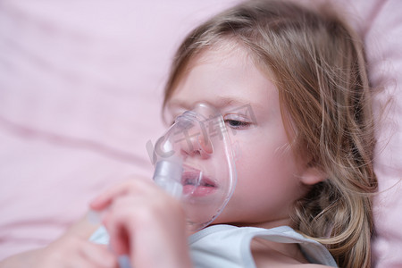 急性结膜炎摄影照片_使用雾化器吸入激素药物的小女孩