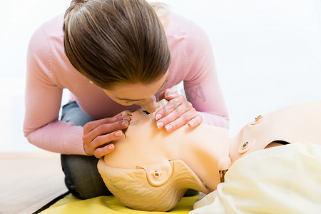 急救措施摄影照片_女性在假人身上训练口对口呼吸捐献