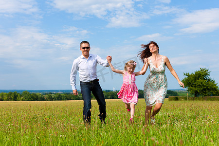 夏天在草地上奔跑的幸福家庭