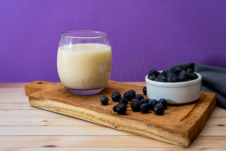 在现代简约的环境中，可以看到一杯牛奶和一些有机蓝莓的高处景色。