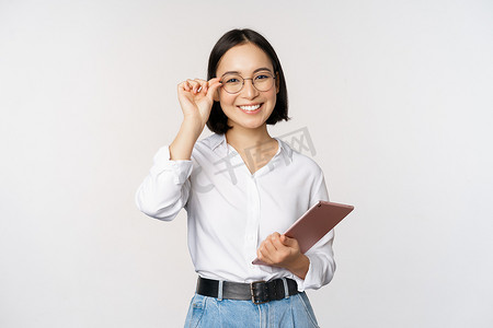 年轻亚洲女商人的形象，戴眼镜的女企业家，拿着平板电脑，戴眼镜看起来很专业，白色背景