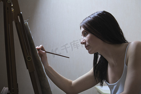 在画架上画画的女人