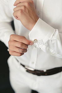 男子在婚礼当天早上穿上衬衫并扣上袖扣