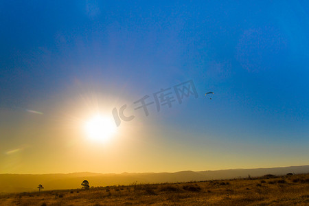 山中日食和天空中滑翔伞的景观