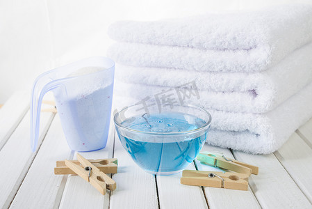浴室浴巾摄影照片_浴巾、洗衣粉、织物柔顺剂和木制衣夹
