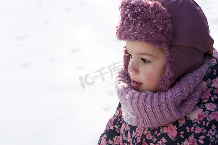 冬天、家庭、童年概念 — 特写肖像真实的学龄前小女婴穿着粉红色暖和的衣服在雪天里行走。