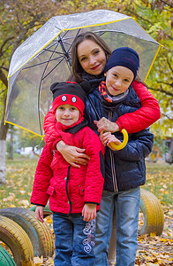 伞下的男孩摄影照片_有两个孩子在伞下的母亲