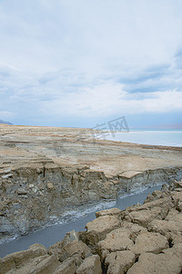 天坑摄影照片_死海海岸线附近充满绿松石水的天坑。