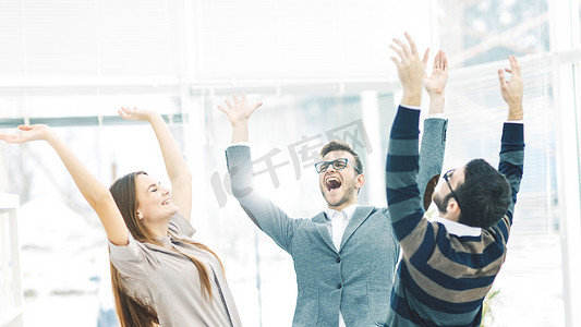 工作胜利摄影照片_胜利的概念-兴高采烈的商业团队站成一圈，举起手来为成功而欢欣鼓舞。