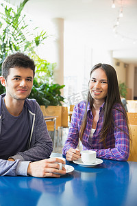 年轻学生在咖啡馆里对着镜头微笑