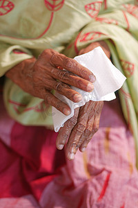 高级妇女用湿巾给他的手消毒。