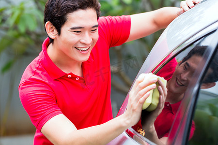 亚洲男子用海绵清洁和洗车