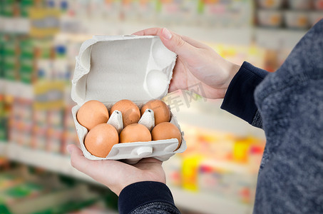 查证摄影照片_超市里拿着鸡蛋盒的男人