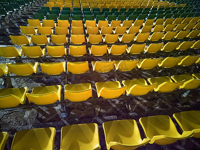 体育场或圆形剧场看台上空荡荡的红色塑料椅子。