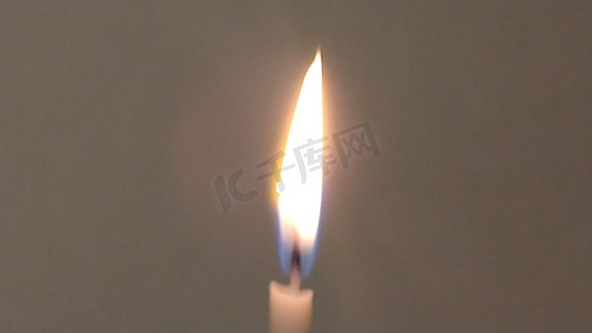 深白色背景上孤独蜡烛的长而均匀的火焰。
