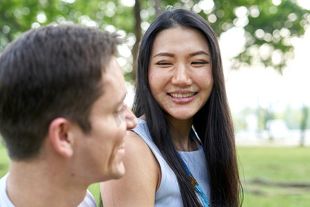 微笑的泰国女人在公园里看着他的夫妇
